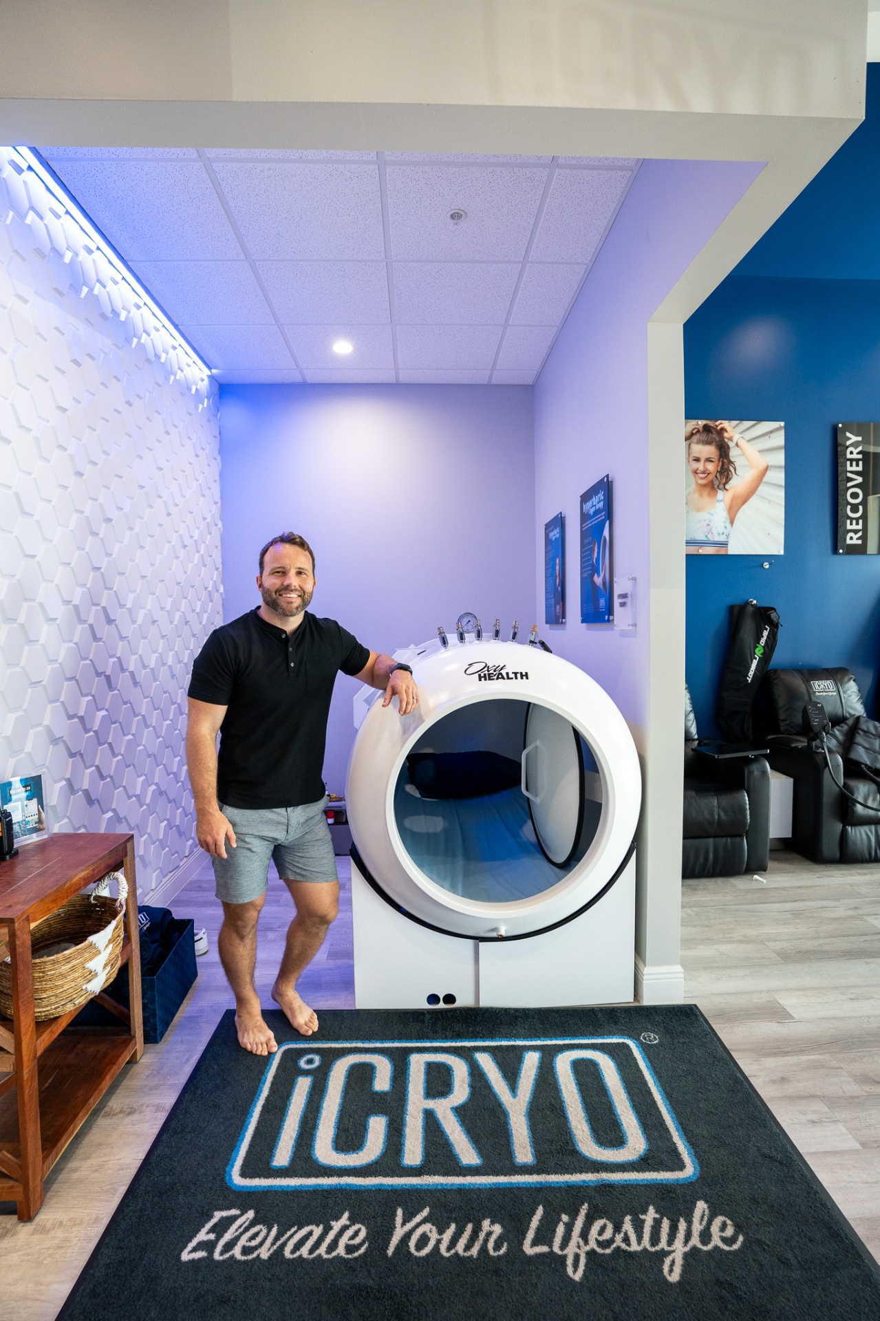 Owner next to the OxyHealth Fortius 420 hard-shell hyperbaric chamber at iCRYO One Loudoun